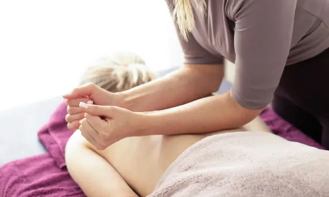 Therapist massaging a client's shoulders and upper back at Ekantik Studio Therapist massaging a client's shoulders and upper back at Ekantik Studio
